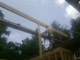 Carpenter setting a ridge beam over a new addition frame — Ice Dam Removal by Roofing Brothers in Weaverville