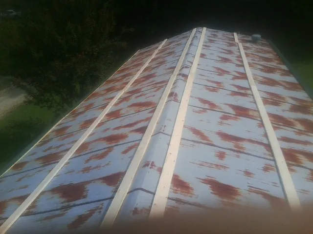 Rusted metal roof panels with new wood purlins before replacement — Storm Damage Roof Repair in Weaverville by Roofing Brothers